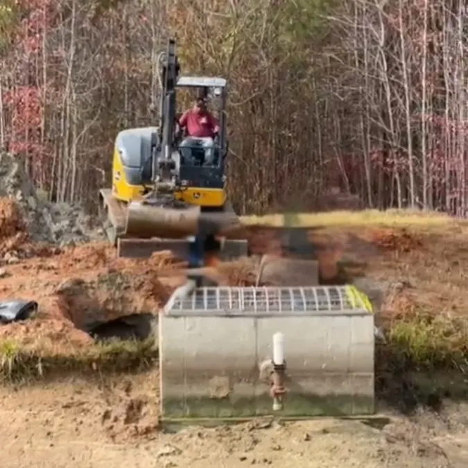 Excavation exposing the reinforced concrete pipe joint under the dam