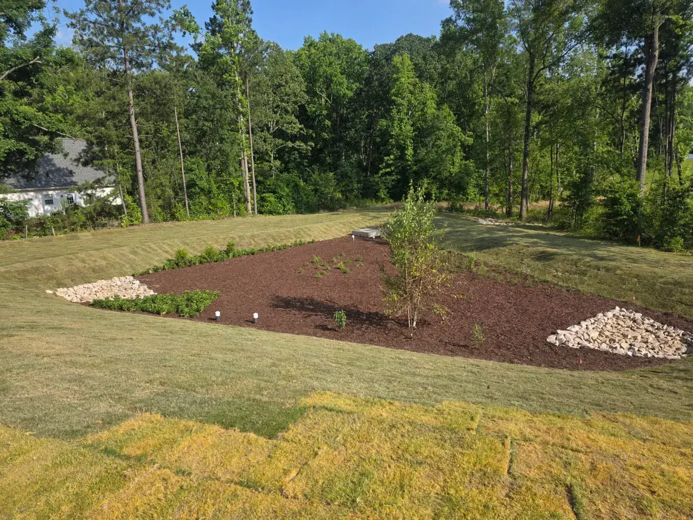 Finished landscaping with mulch beds and sod by Delcid in North Carolina