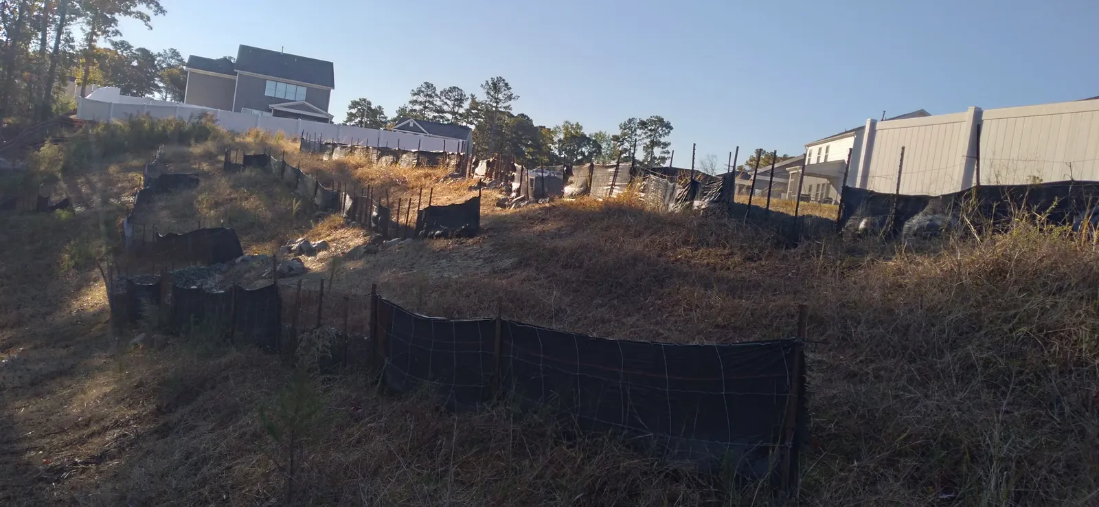 Silt fence along a graded slope before stabilization at Autumnwood
