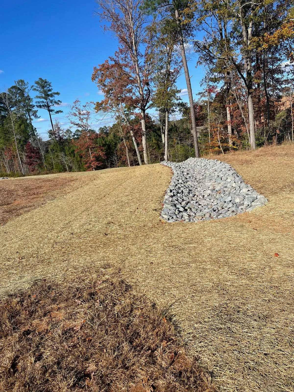 Hydroseeded slope with a rip-rap channel after stabilization at Autumnwood