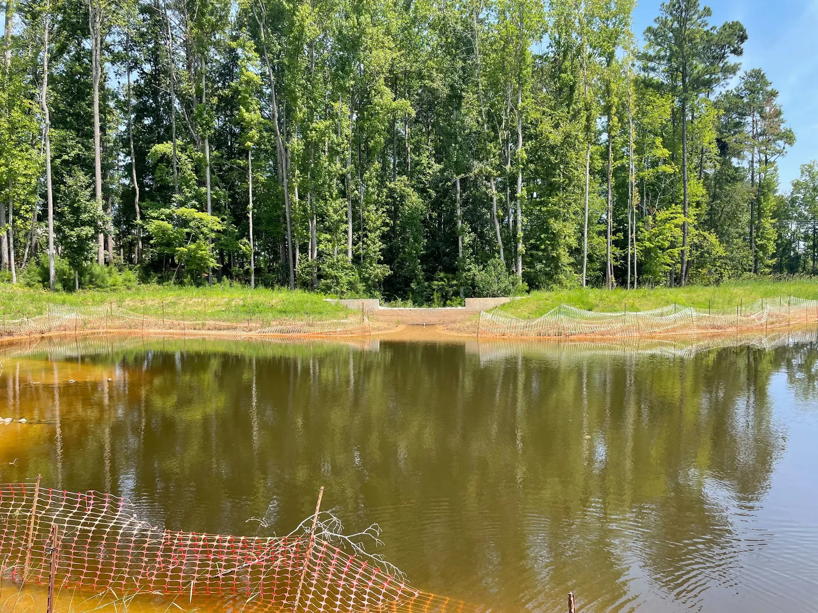 Wide view of a concrete weir and pond outlet structure