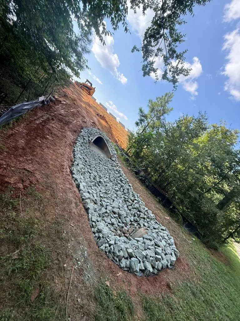 Rip-rap dissipator apron at a culvert outlet on a graded slope