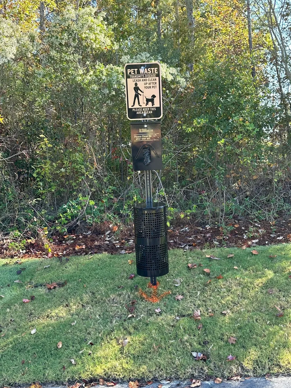 Pet waste station installed on a community lawn