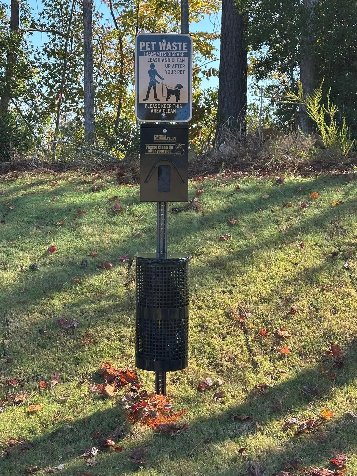 Pet waste station on a wooded community lot