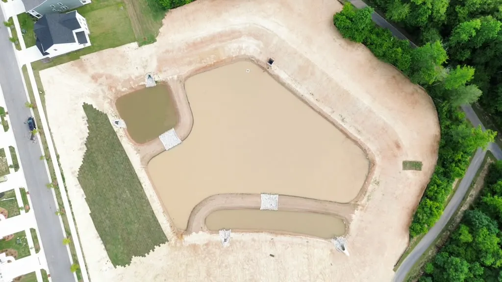 Aerial view of an unfinished stormwater pond before Delcid's work