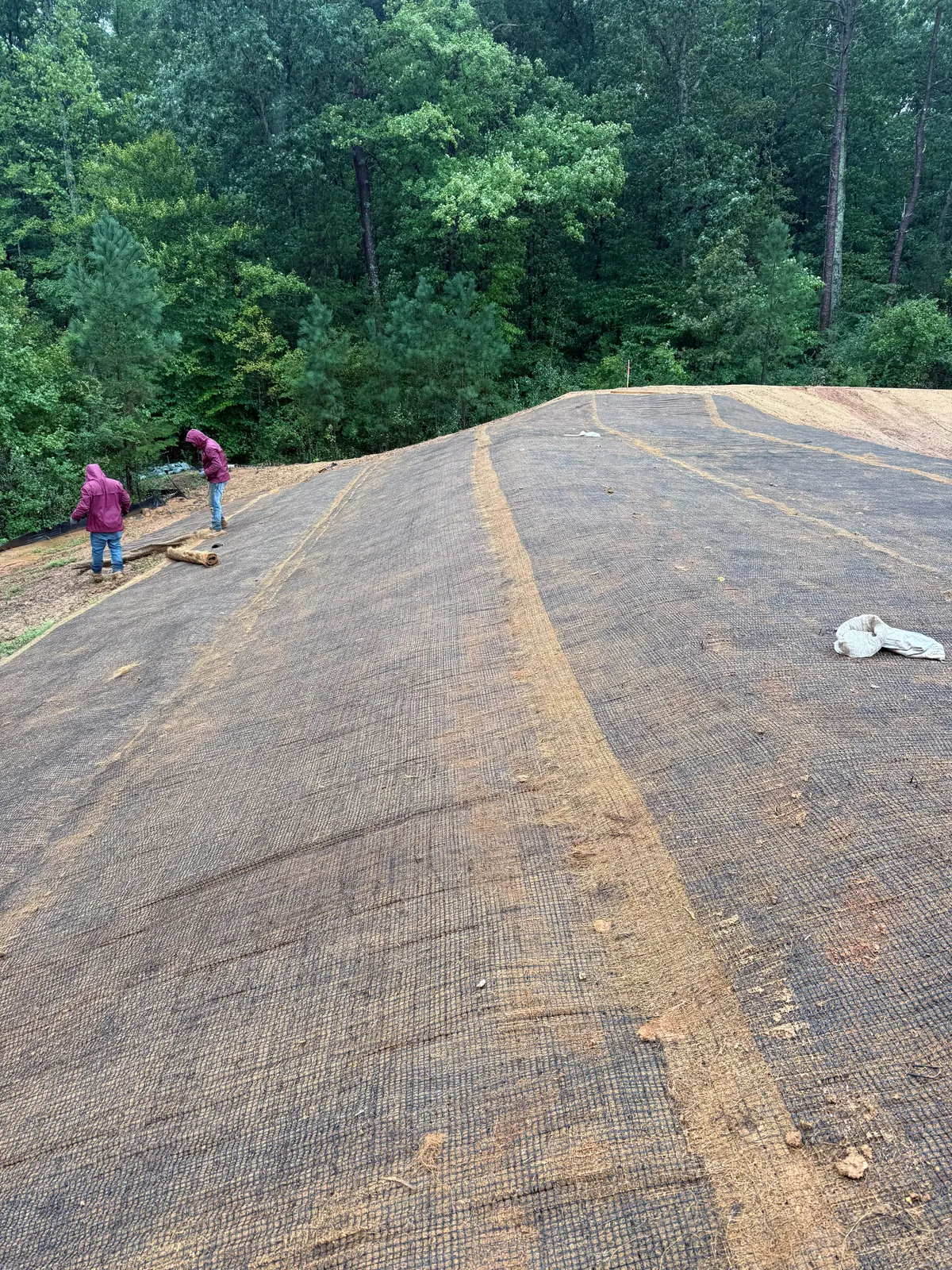 Rolling out erosion control matting at Sagecroft